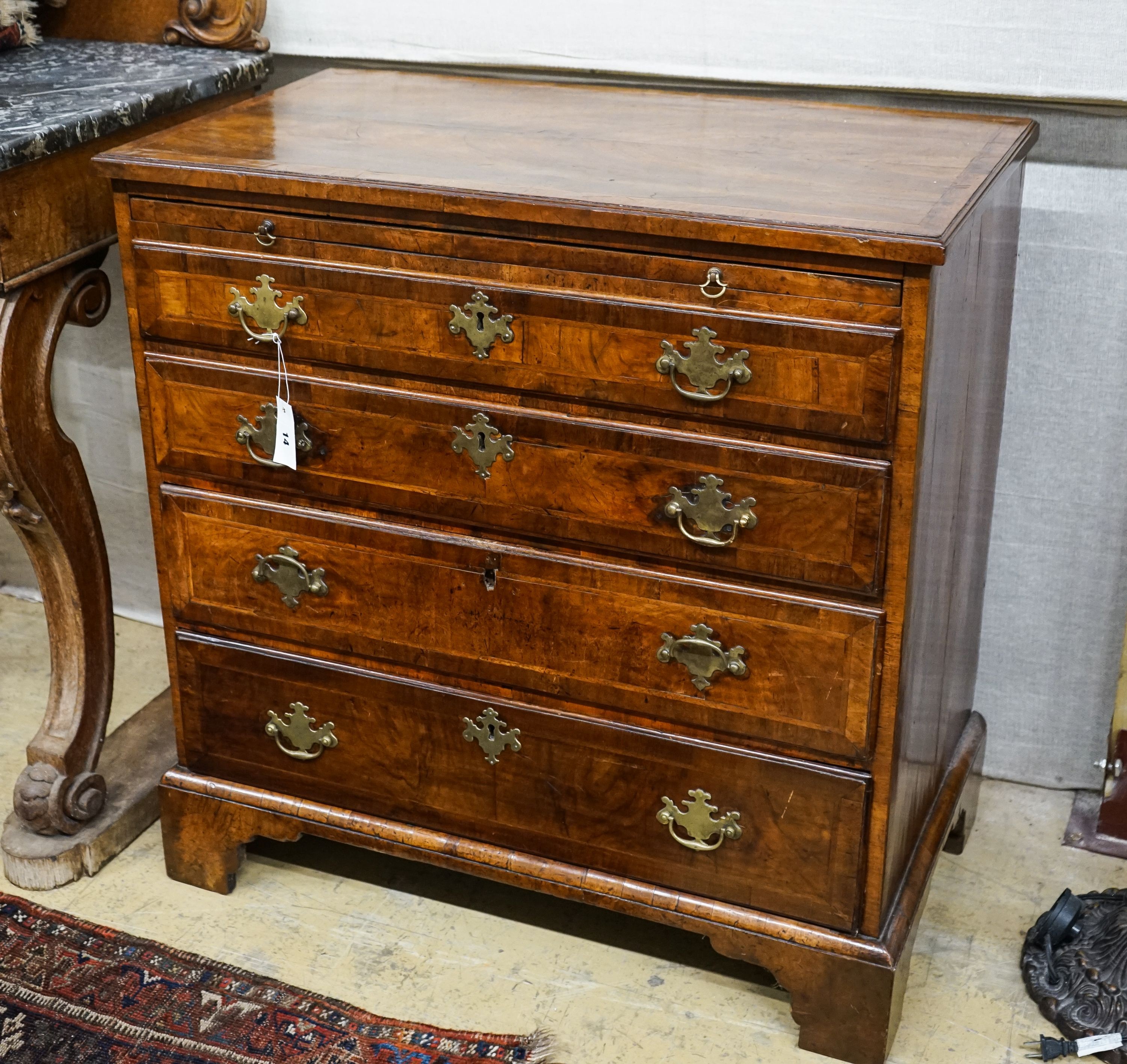 An 18th century and later feather banded walnut chest with slide, width 84cm, depth 49cm, height 86cm